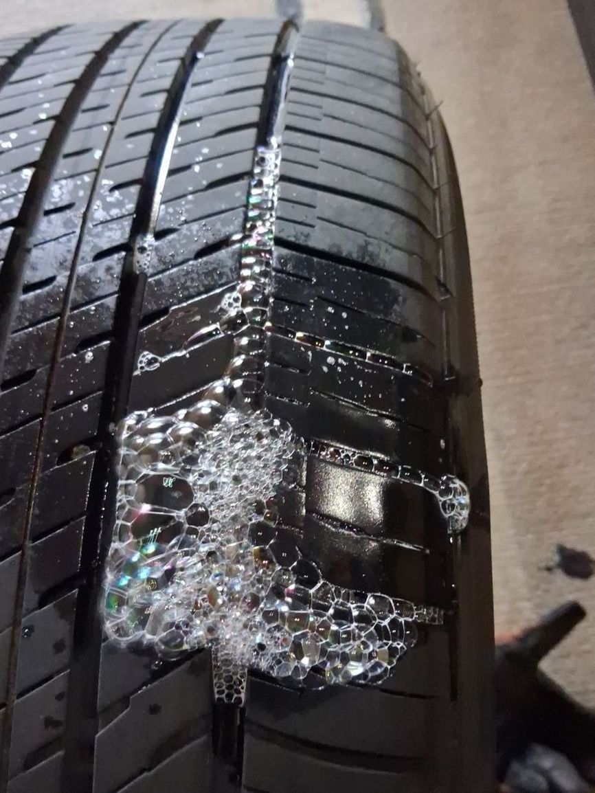Soapy water bubbling on a tire tread, showing where the air leaks out
