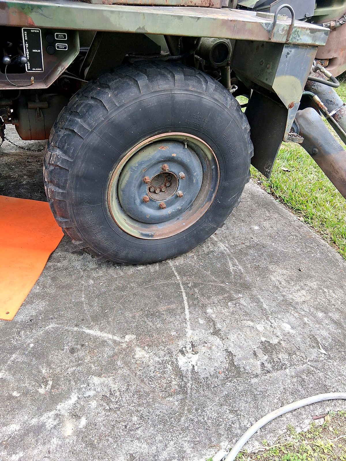 Big off road tire on a camouflage military truck, ready to come off