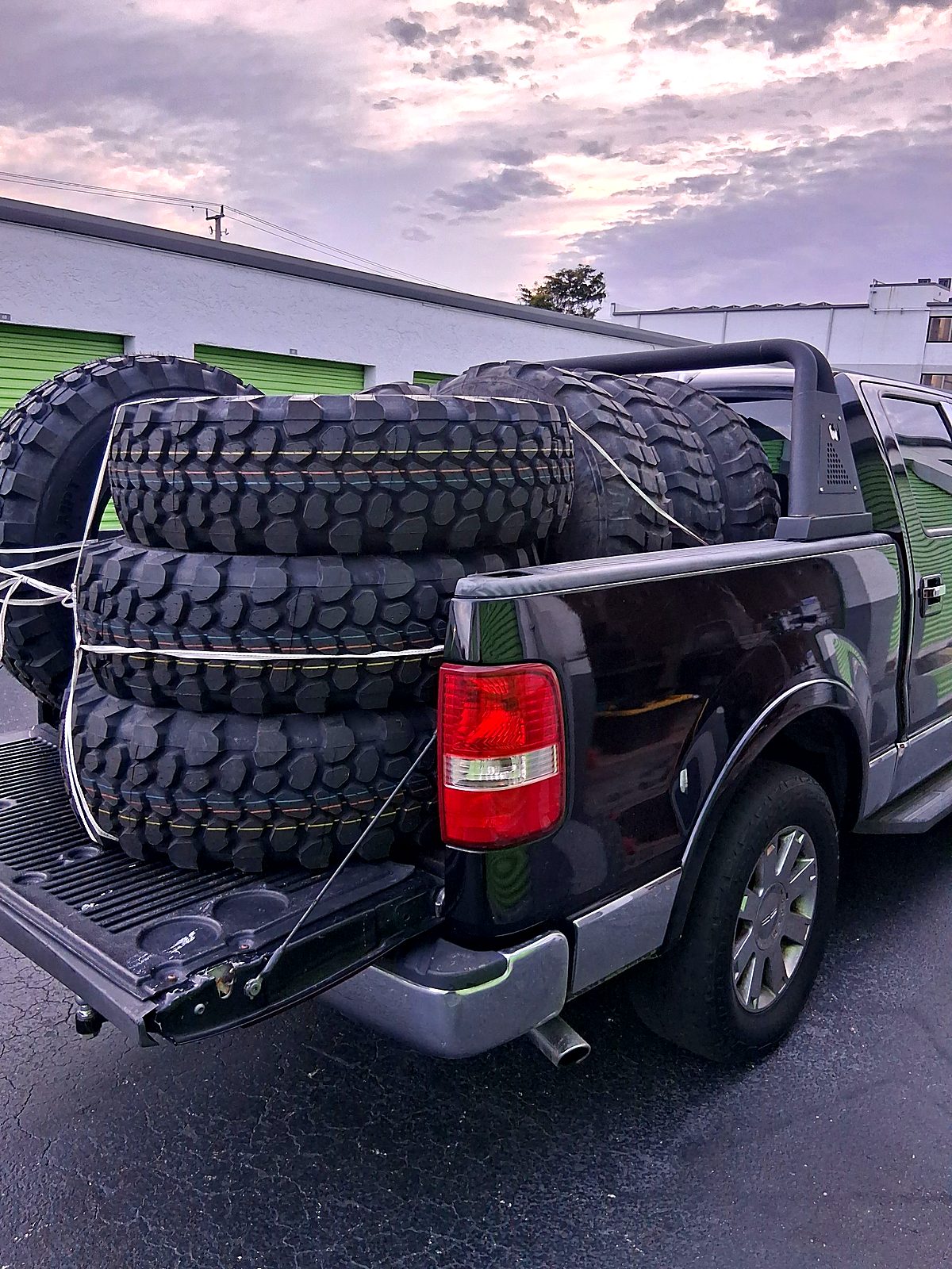 Pickup truck with its bed stacked high with off road tires
