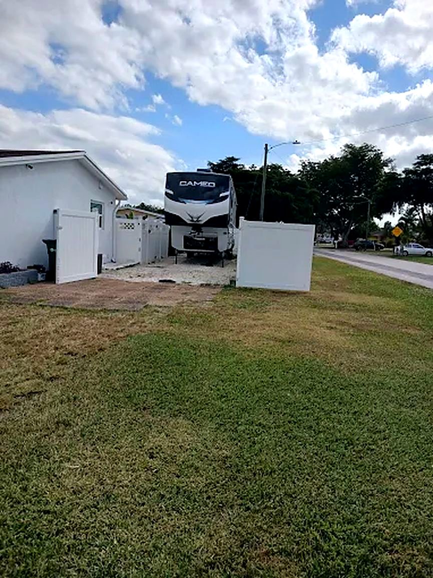 Travel trailer parked beside a house, a job on a big rig