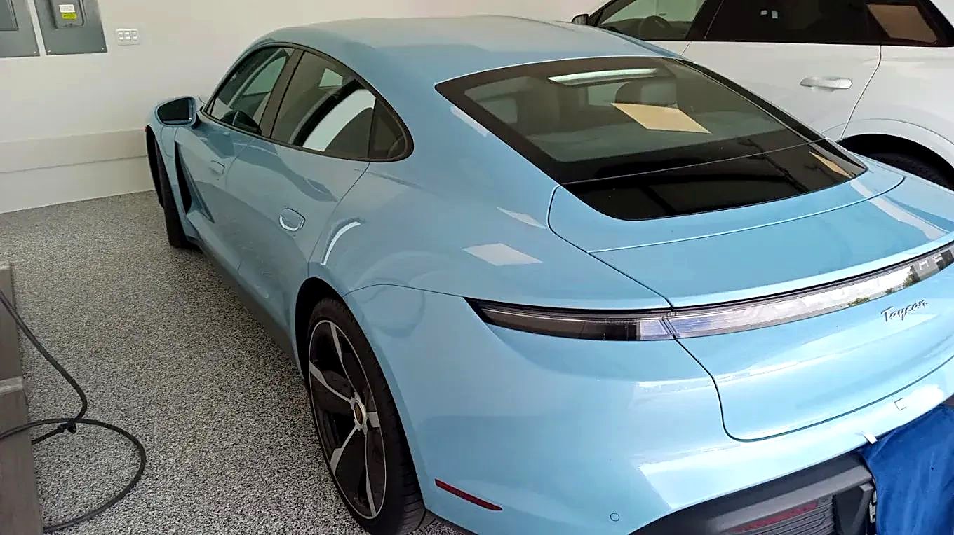 Light blue Porsche Taycan parked in a garage