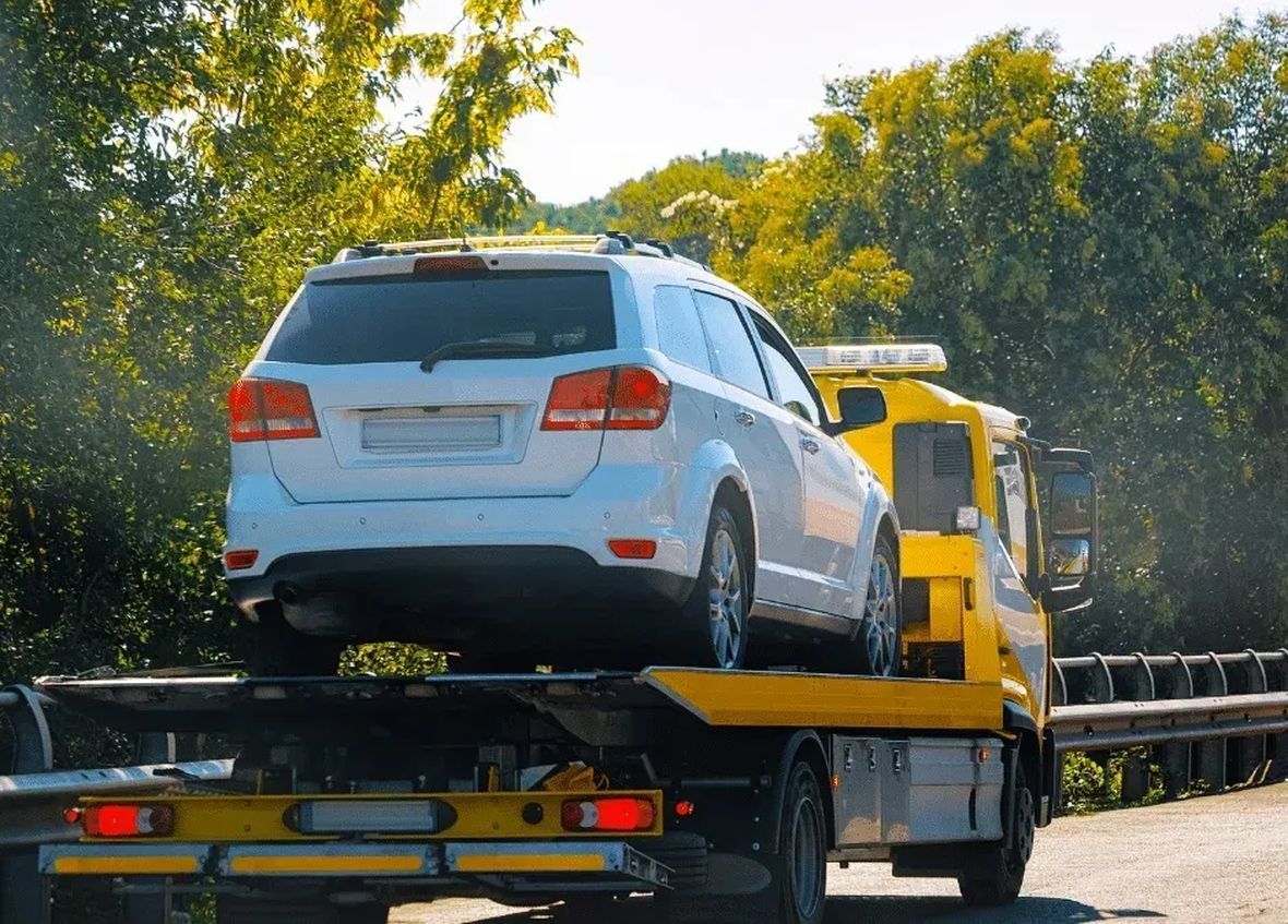 White SUV loaded on a flatbed tow truck