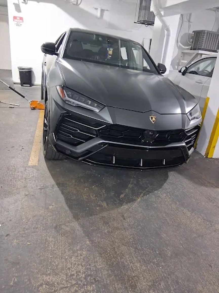 Grey Lamborghini Urus parked in a garage entrance